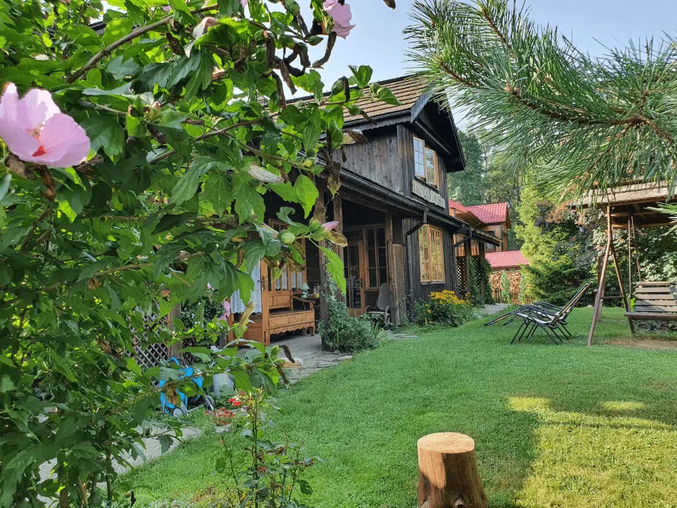 Wejście do karpackiego dworku od strony ogrodu oraz dwa rozłożone leżaki