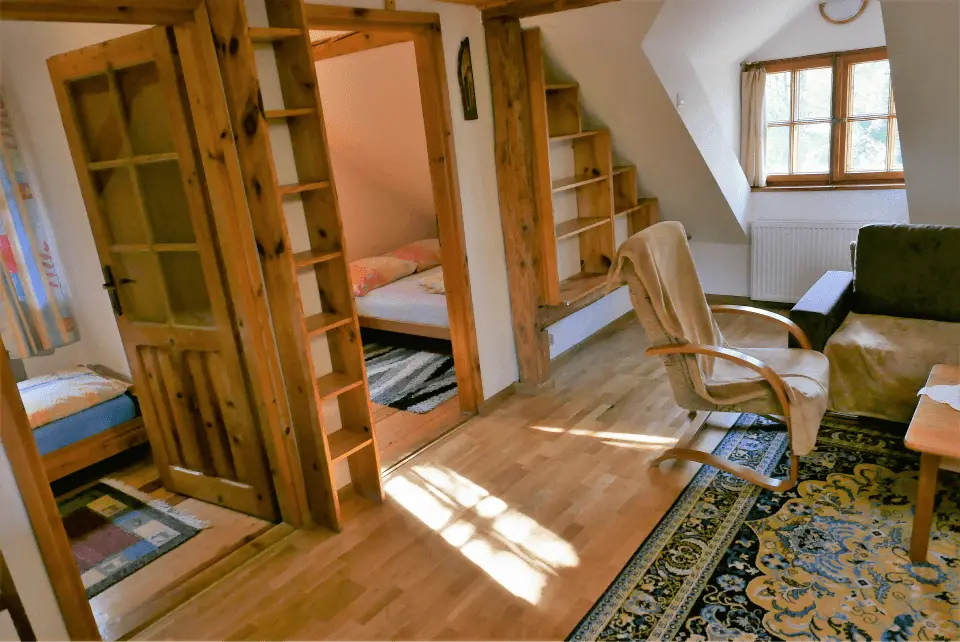 Otwarte wejścia do pokoi oraz mały salonik z bujanymi krzesłami